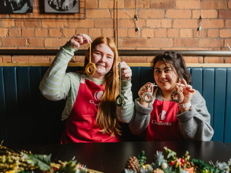 Two people smiling at a Christmas craft class